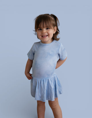 Toddler wearing light blue tie-dye short-sleeve bodysuit dress with gathered skirt.